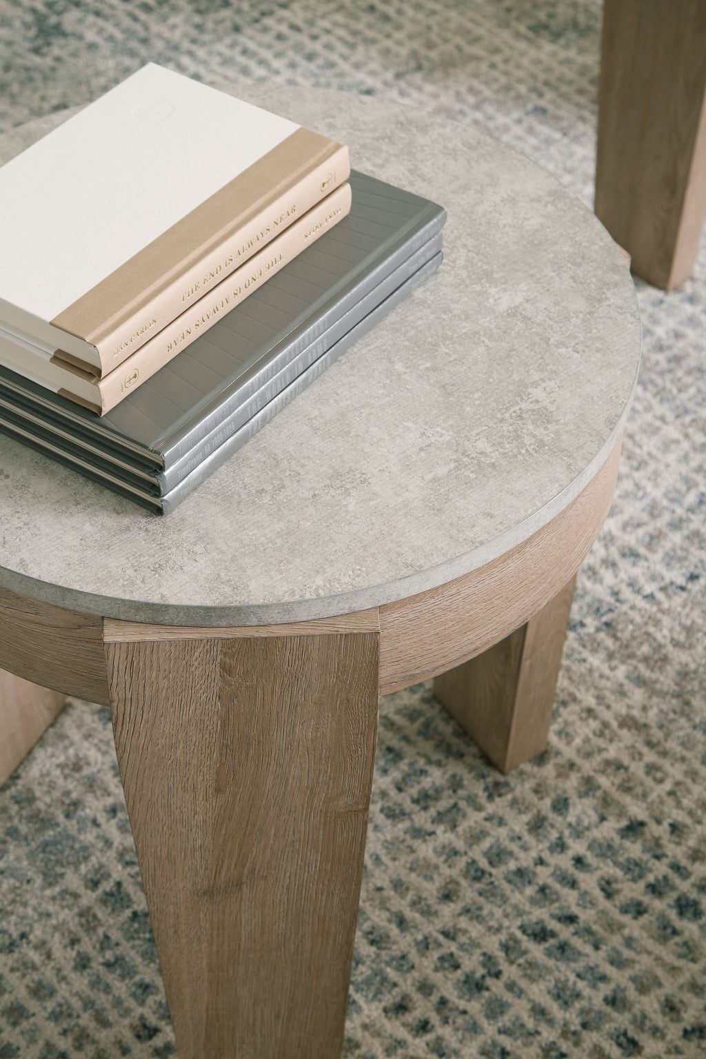 Round occasional table top with light brown wood finish and tapered legs