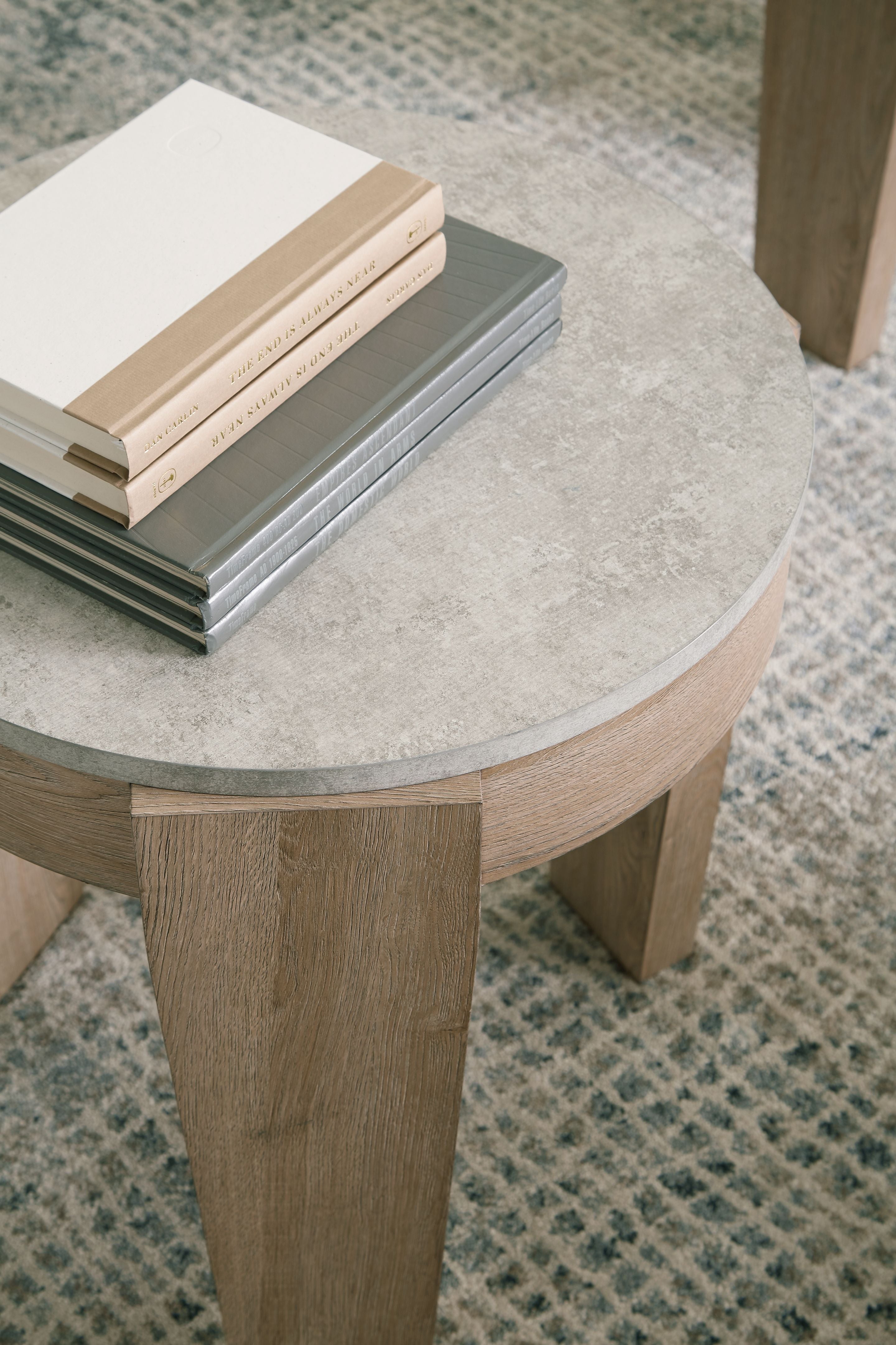Round occasional table top with light brown wood finish and tapered legs