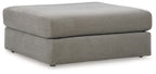 Upholstered ottoman in ash gray with rounded square top and low block feet