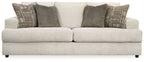 Stone sleeper sofa with two dark solid pillows and patterned decorative cushions