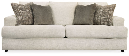 Stone sleeper sofa with two dark solid pillows and patterned decorative cushions