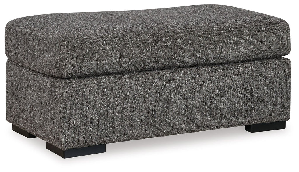 Pewter fabric ottoman with rounded top, cushioned seat, and black base