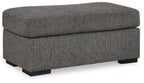 Pewter fabric ottoman with rounded top, cushioned seat, and black base