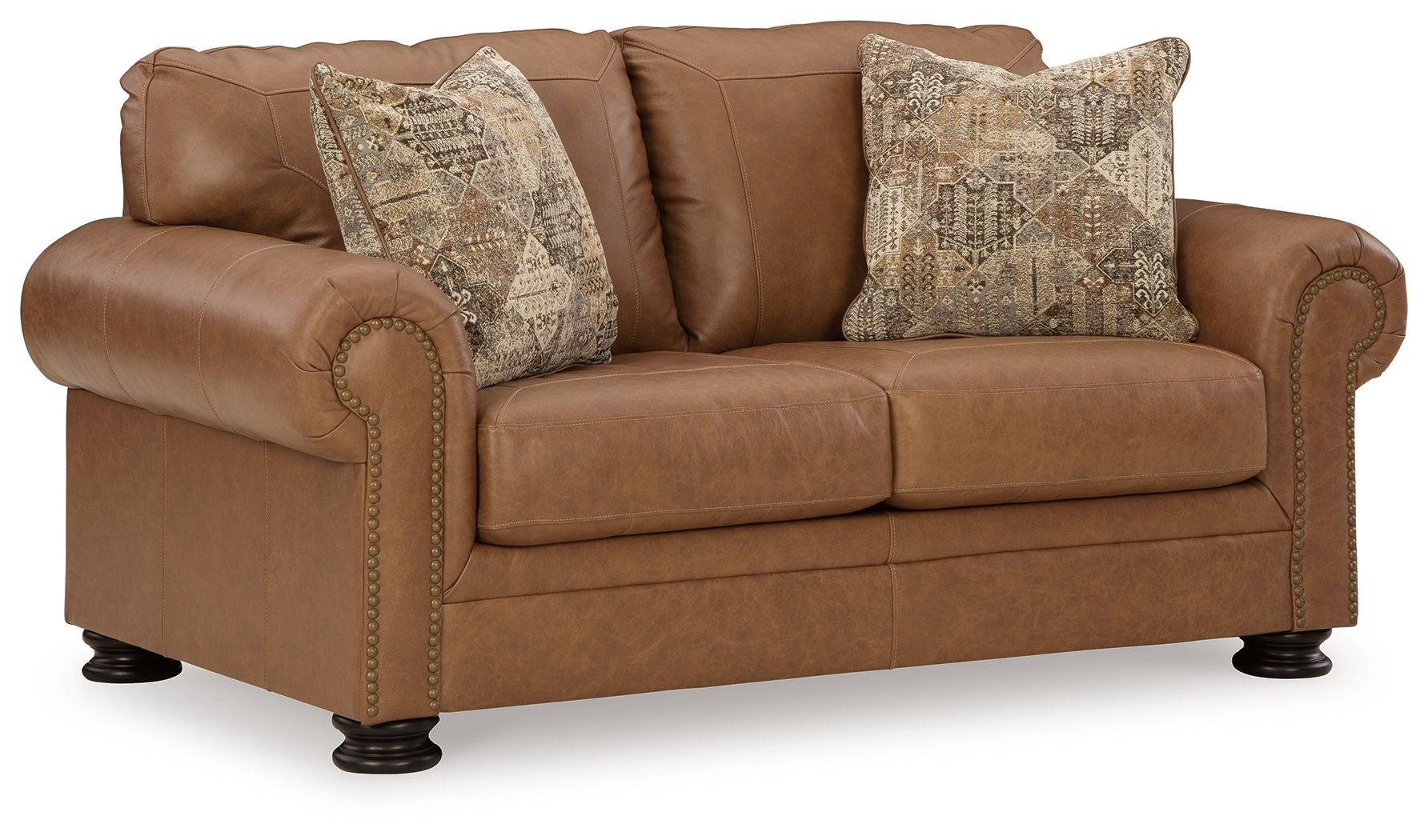 Caramel loveseat with rolled arms, nailhead trim, and two patterned accent pillows