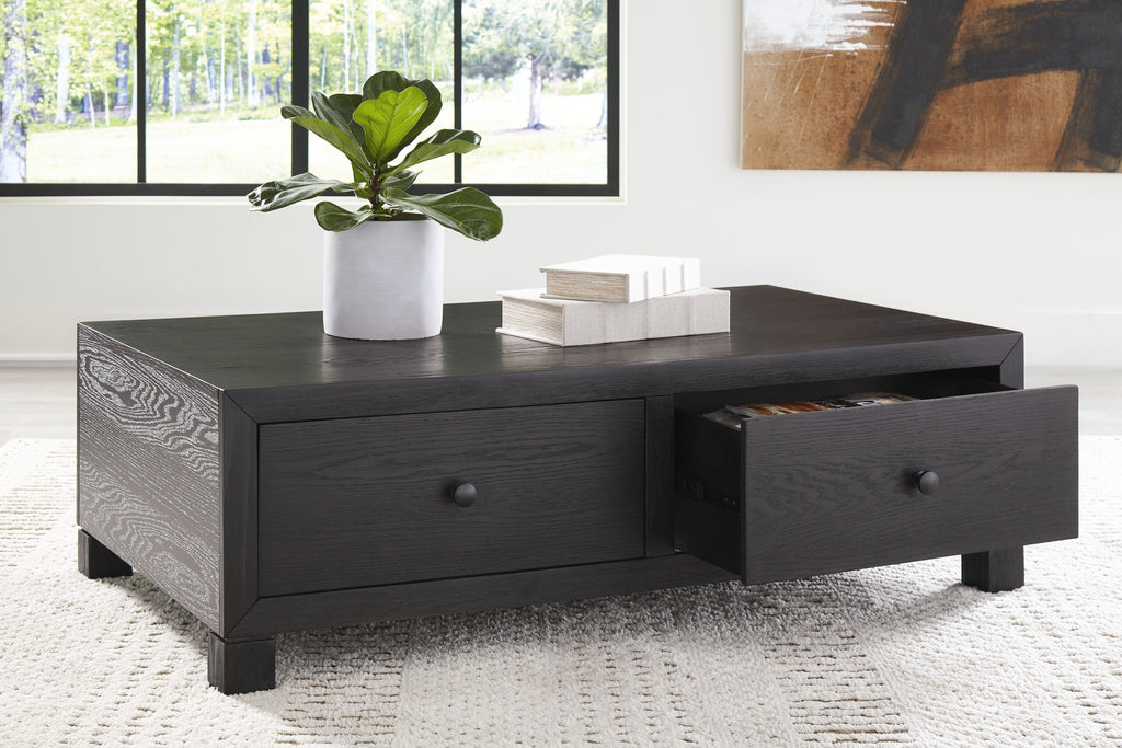 Dark wood cocktail table with two drawers; right drawer is open