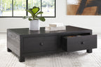 Dark wood cocktail table with two drawers; right drawer is open