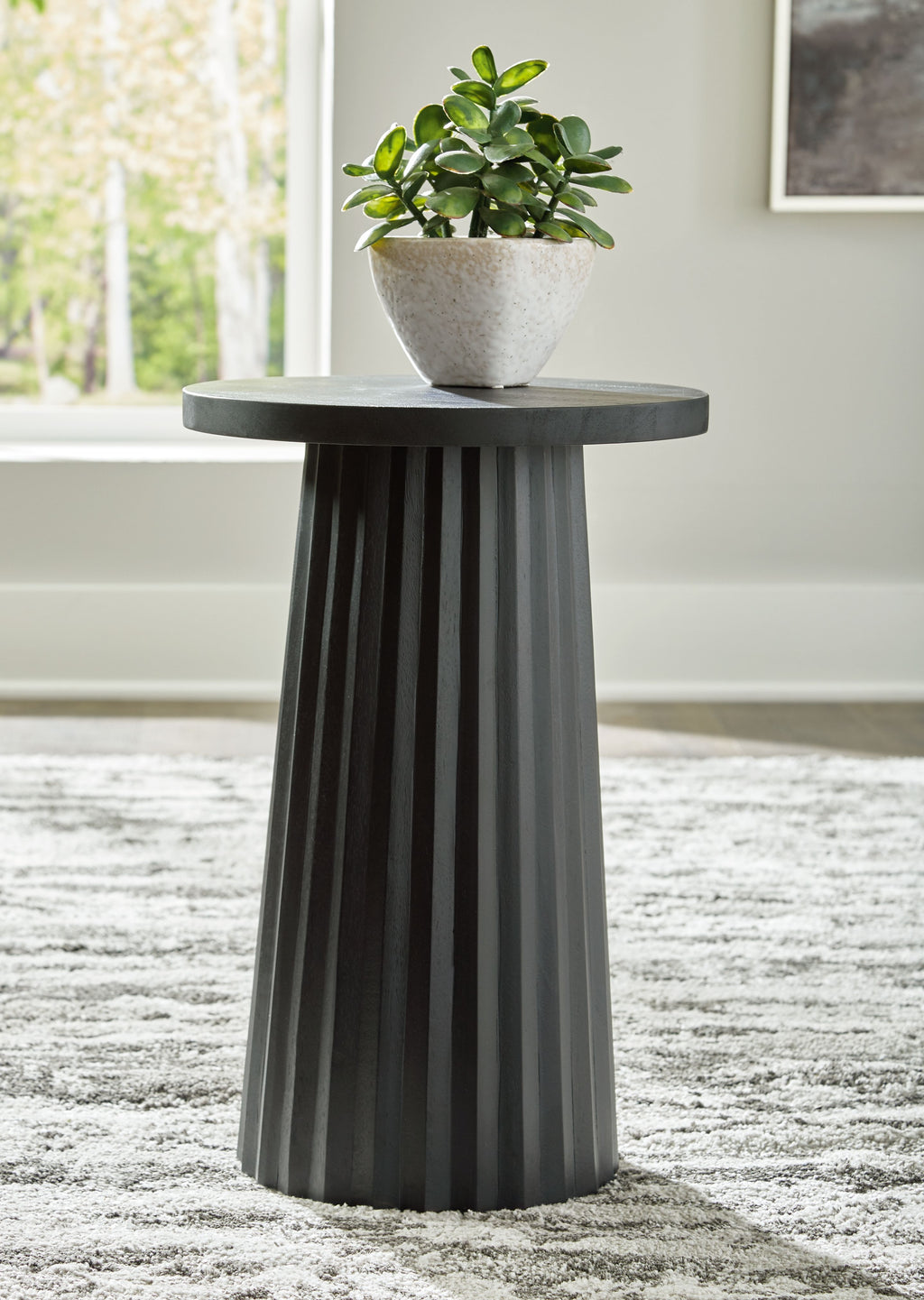 Black round accent table with planter on top