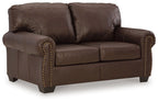 Dark brown loveseat with rolled arms, tufted back, and nailhead trim