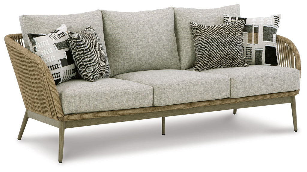 Beige sofa with light gray seat cushions and three patterned throw pillows