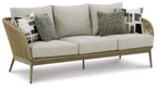 Beige sofa with light gray seat cushions and three patterned throw pillows