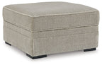 Light beige woven storage ottoman with hinged top and black legs