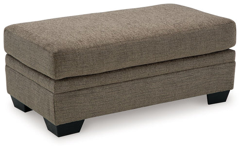 Upholstered ottoman in dark brown fabric with stitched top, black legs.