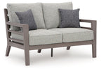 Gray loveseat with two square patterned throw pillows and two matching seat cushions