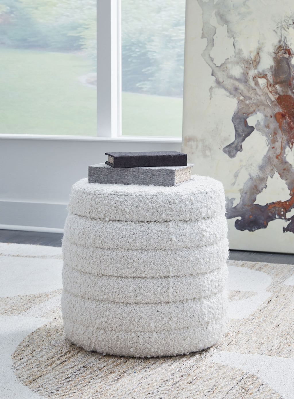 Ivory round storage ottoman with dense textured fabric and closed lid