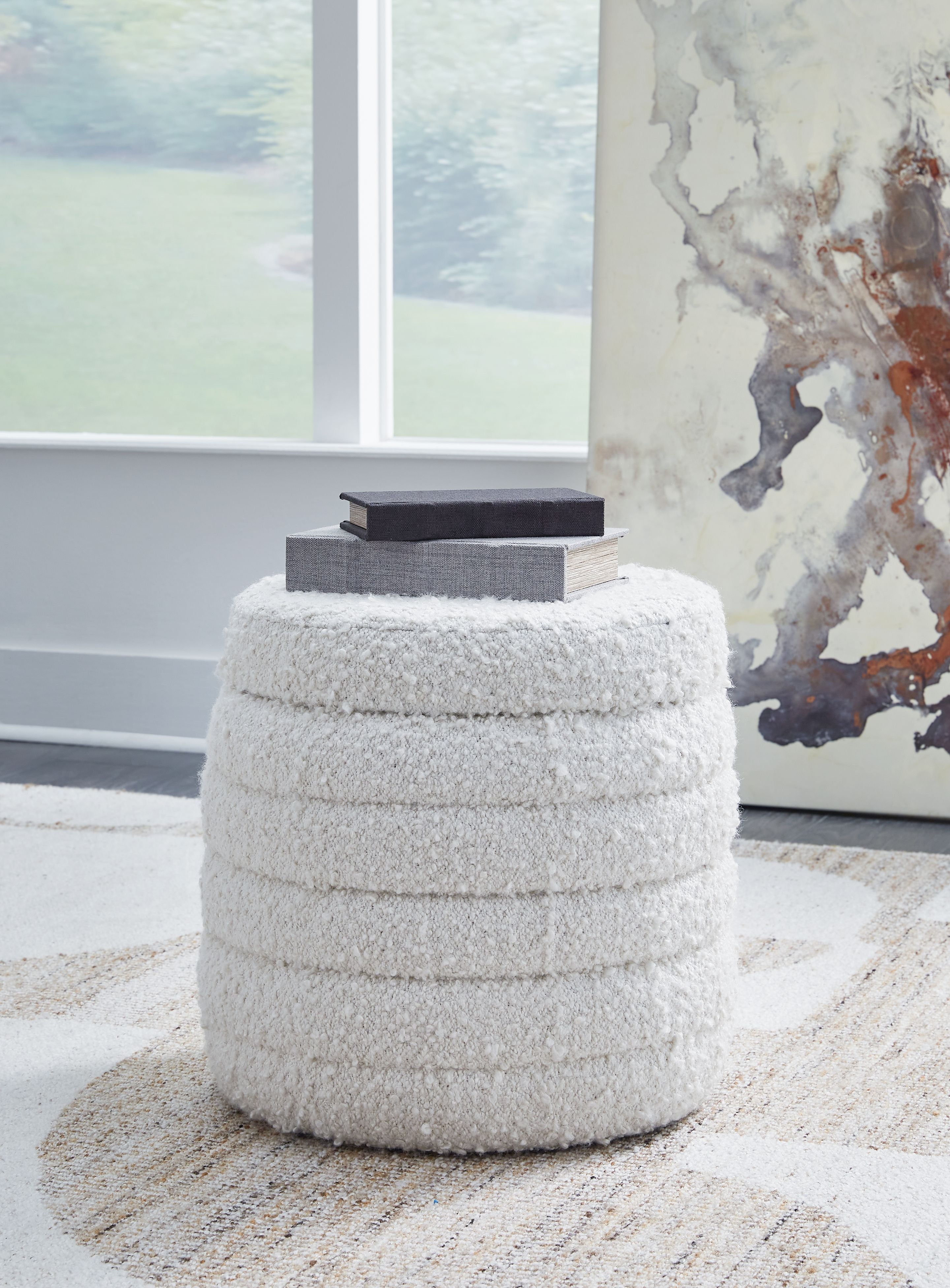Ivory round storage ottoman with dense textured fabric and closed lid