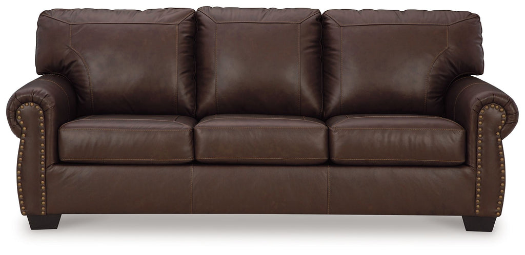 Dark brown leather sofa with rolled arms, tufted back, and studded trim