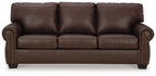 Dark brown leather sofa with rolled arms, tufted back, and studded trim