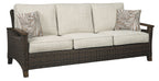 Medium brown wicker sofa with beige seat and back cushions, decorative throw pillows