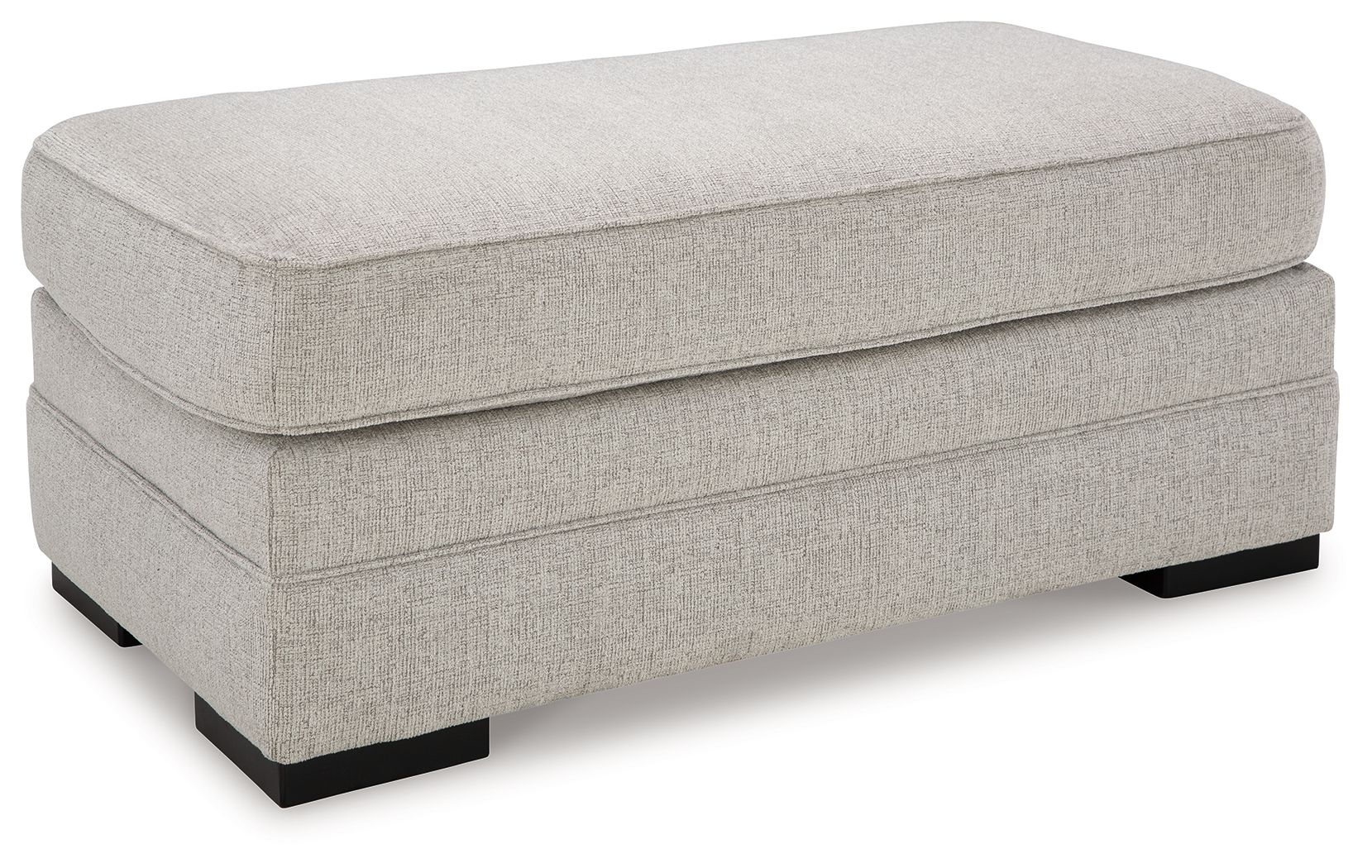 Light gray upholstered ottoman with rectangular top and stitched side panels