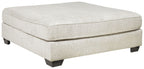 Oversized accent ottoman in parchment fabric with square top and dark legs